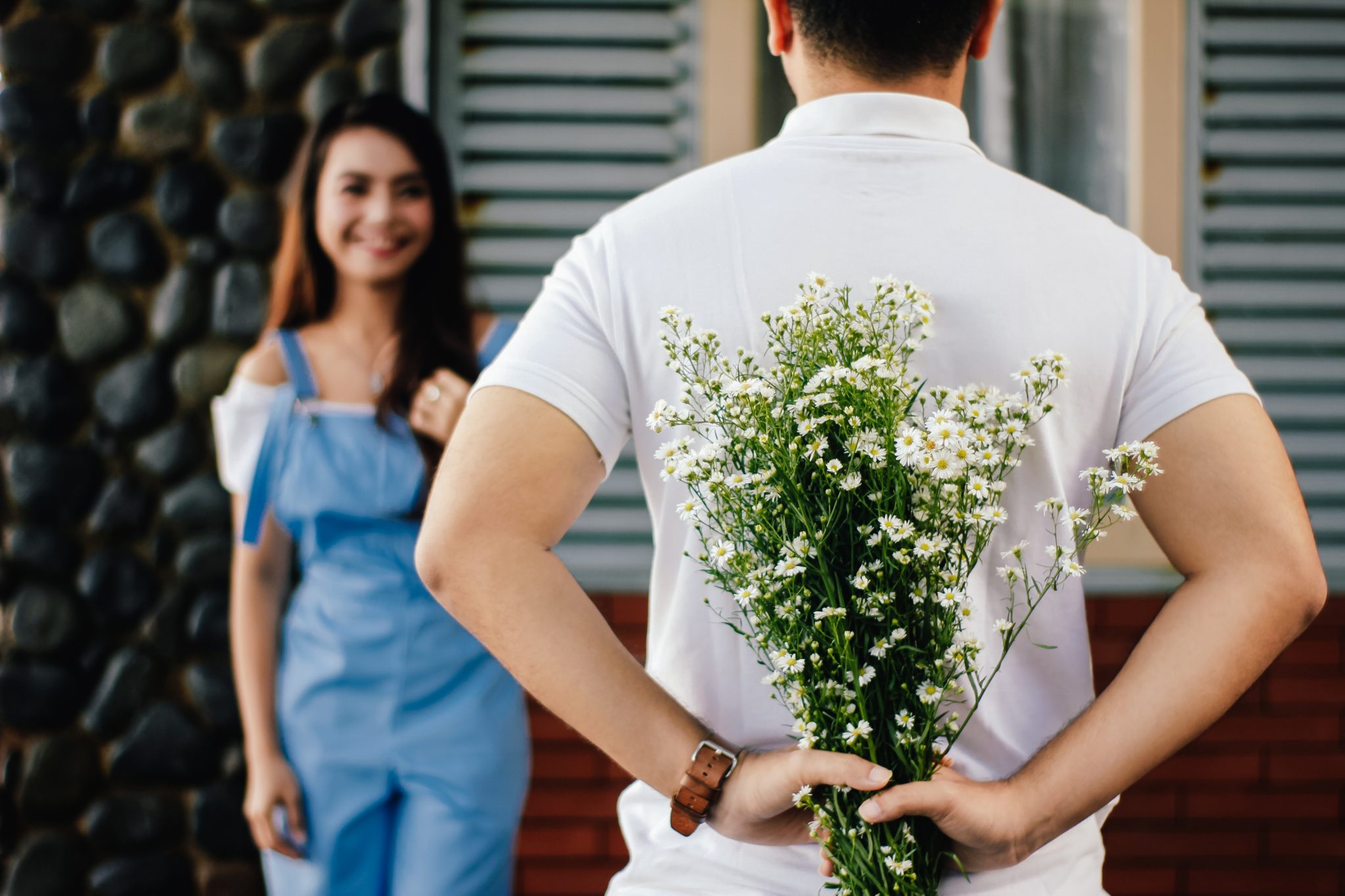 Man holding flowers to surprise wife for date night