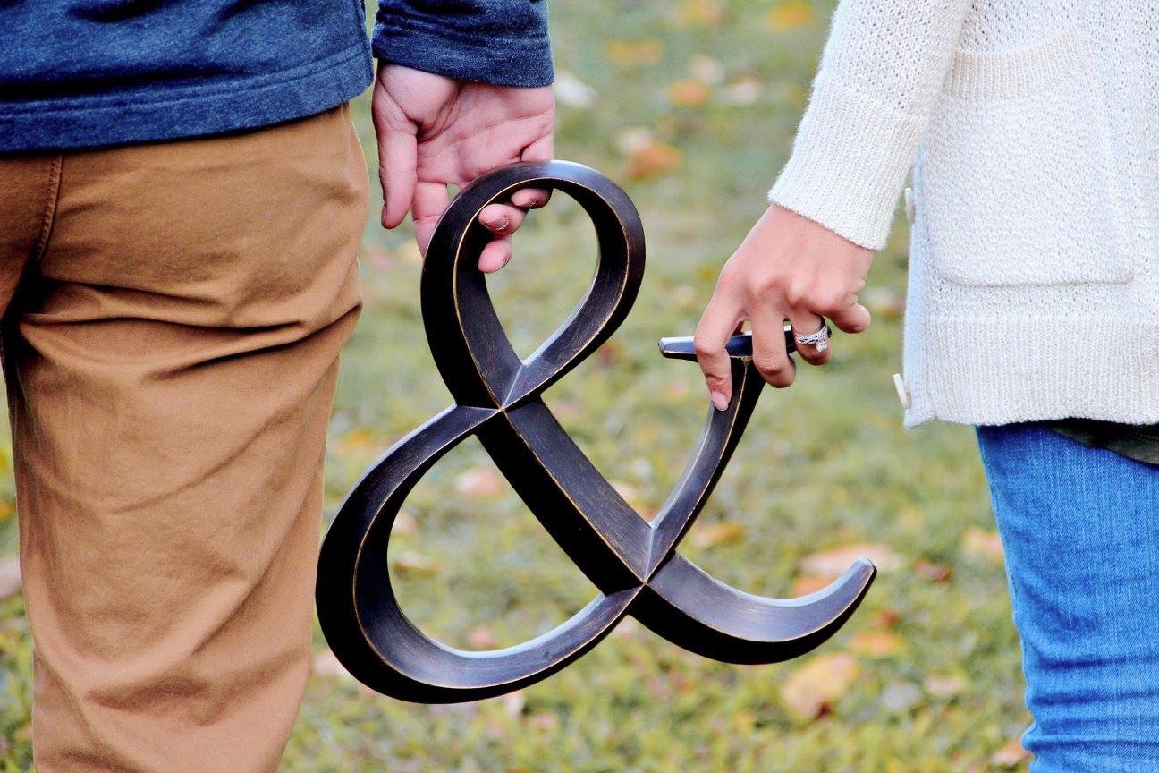 Married couple holding ampersand