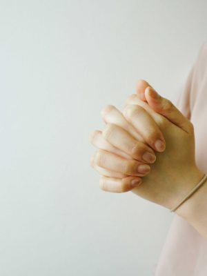 Woman folding hands in prayer