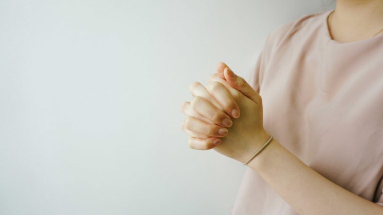 Woman folding hands in prayer